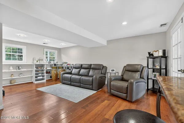 a living room with furniture and hard wood flooring