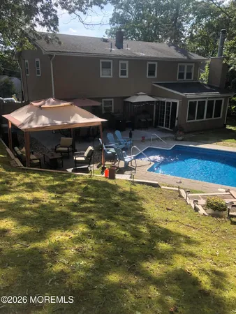 a view of a house with pool and chairs