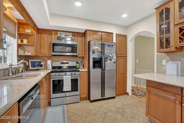 a kitchen with stainless steel appliances granite countertop a stove refrigerator and a sink