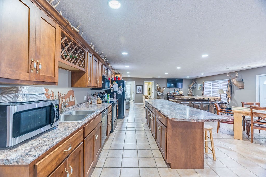 8496 South Madisonville Road Hopkinsville, KY 42240 - Photo 9 of 22 a large kitchen with stainless steel appliances granite countertop a large counter top and a stove