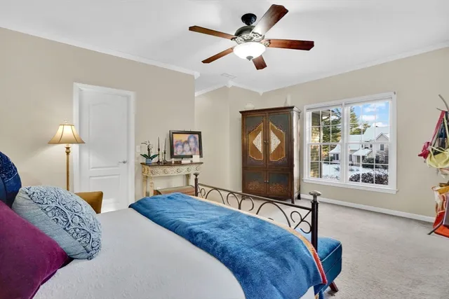 a bedroom with a bed a chandelier and a flat screen tv