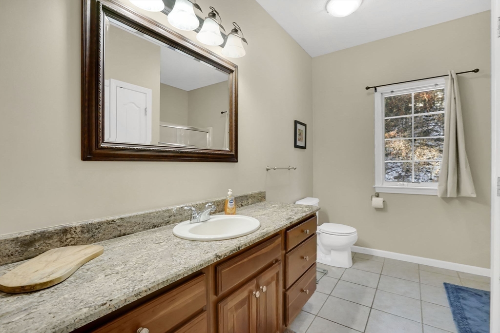 1 Pioneer Drive Palmer, MA 01069 - Photo 22 of 31 a bathroom with a granite countertop sink a toilet and mirror