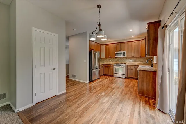 a view of a kitchen with wooden floor electronic appliances and wooden floor
