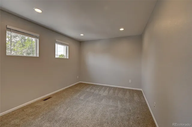 a view of an empty room with a fireplace and a window