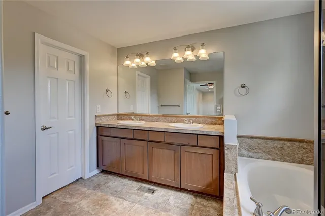 a bathroom with a granite countertop sink mirror and a bathtub