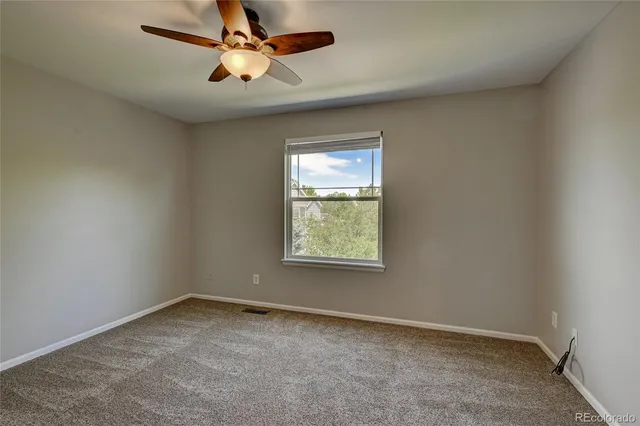 a view of an empty room and a ceiling fan