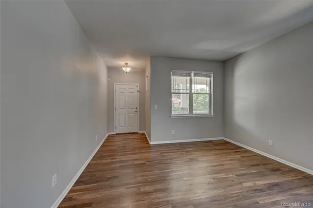 wooden floor in an empty room with a window