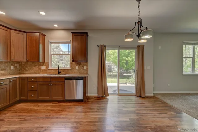 a view of a kitchen with a sink dishwasher and wooden floor