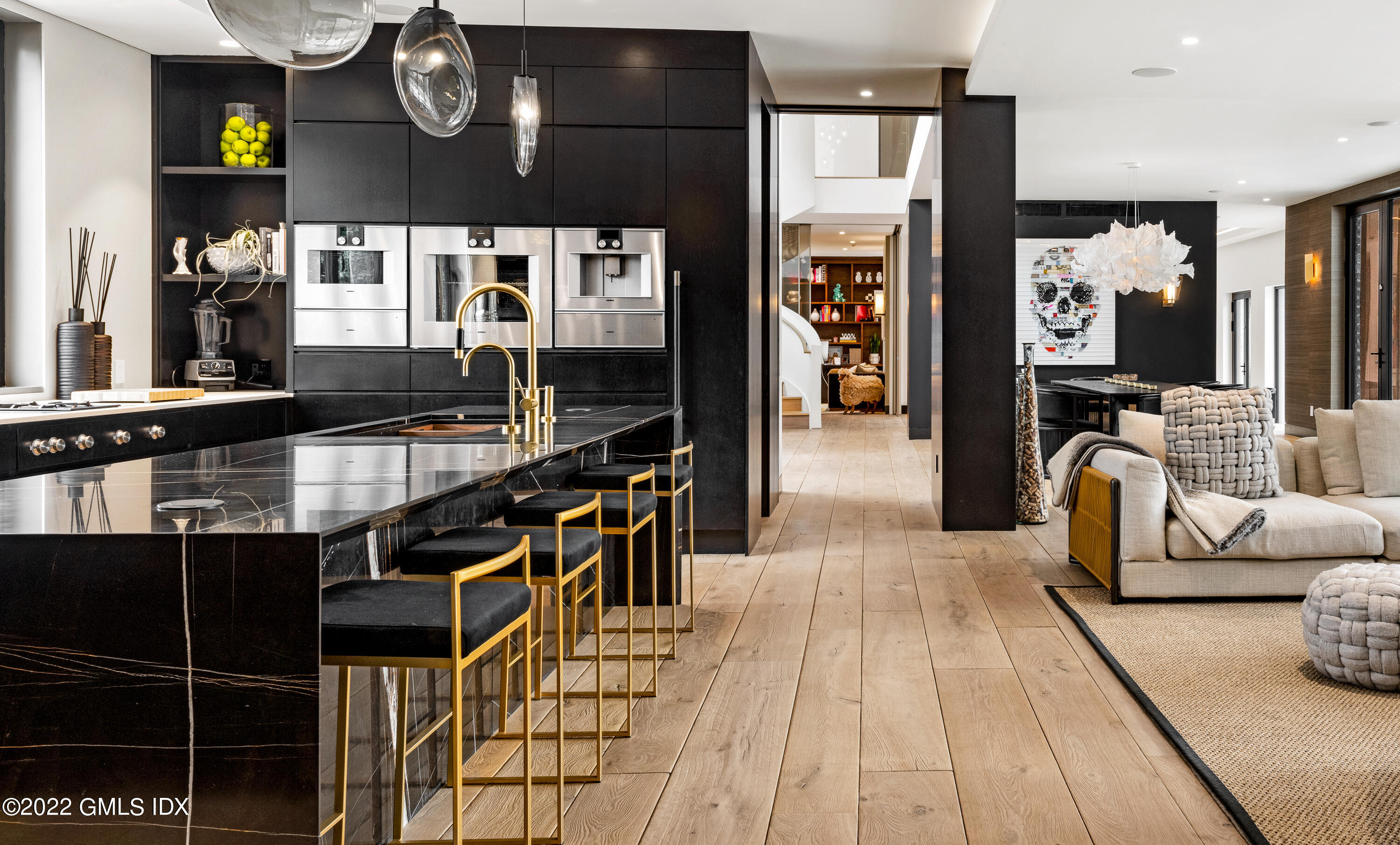 34 Beechcroft Road Greenwich, CT 06830 - Photo 11 of 25 a hallway with couches a flat tv screen and a dining table with wooden floor