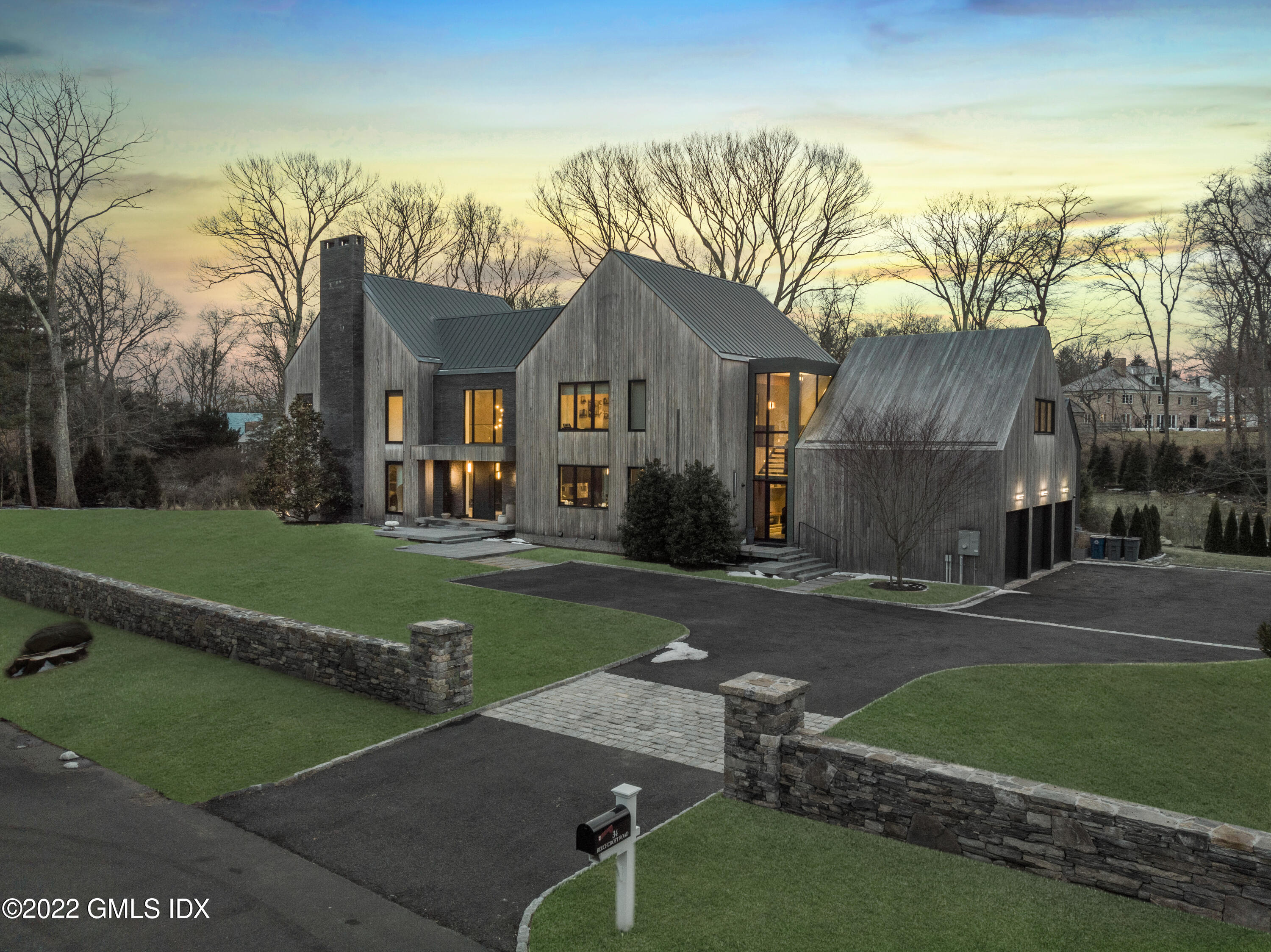 34 Beechcroft Road Greenwich, CT 06830 - Photo 2 of 25 a front view of a house with a yard and garage
