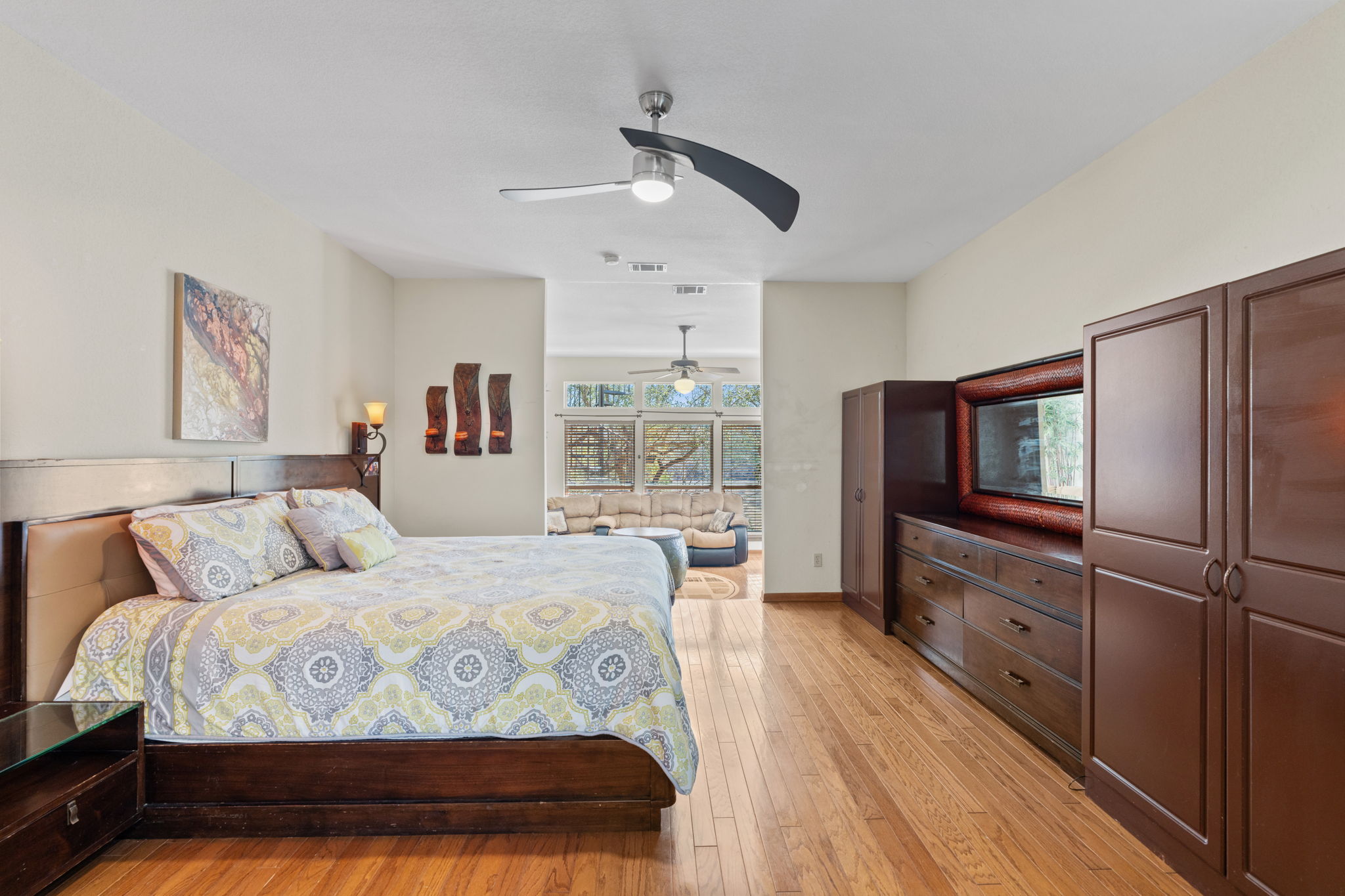 3405 Bee Creek Road Spicewood, TX 78669 - Photo 14 of 40 a bedroom with a bed a dresser with wooden floor