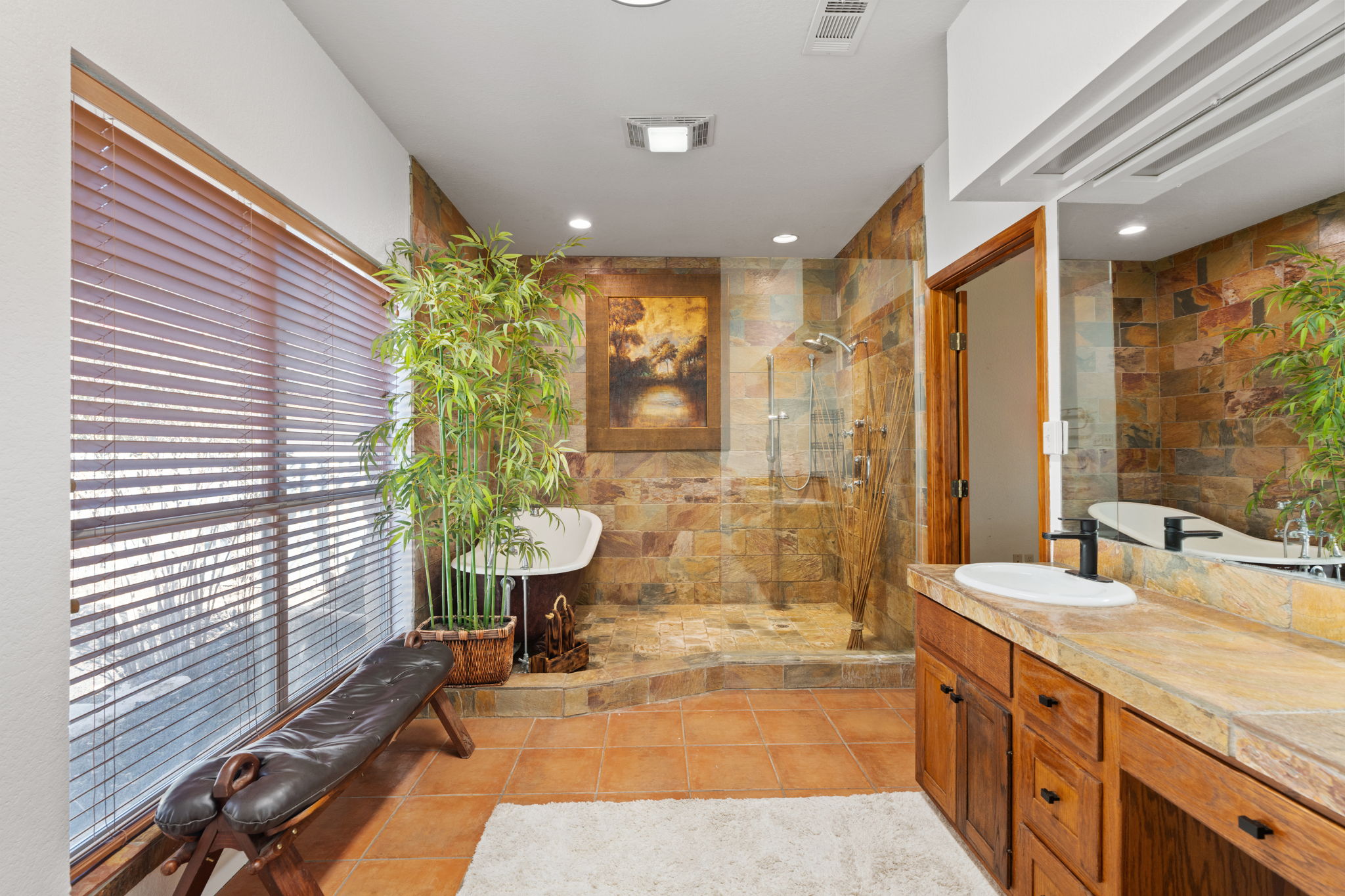 3405 Bee Creek Road Spicewood, TX 78669 - Photo 19 of 40 a spacious bathroom with a granite countertop sink a toilet a large mirror and shower