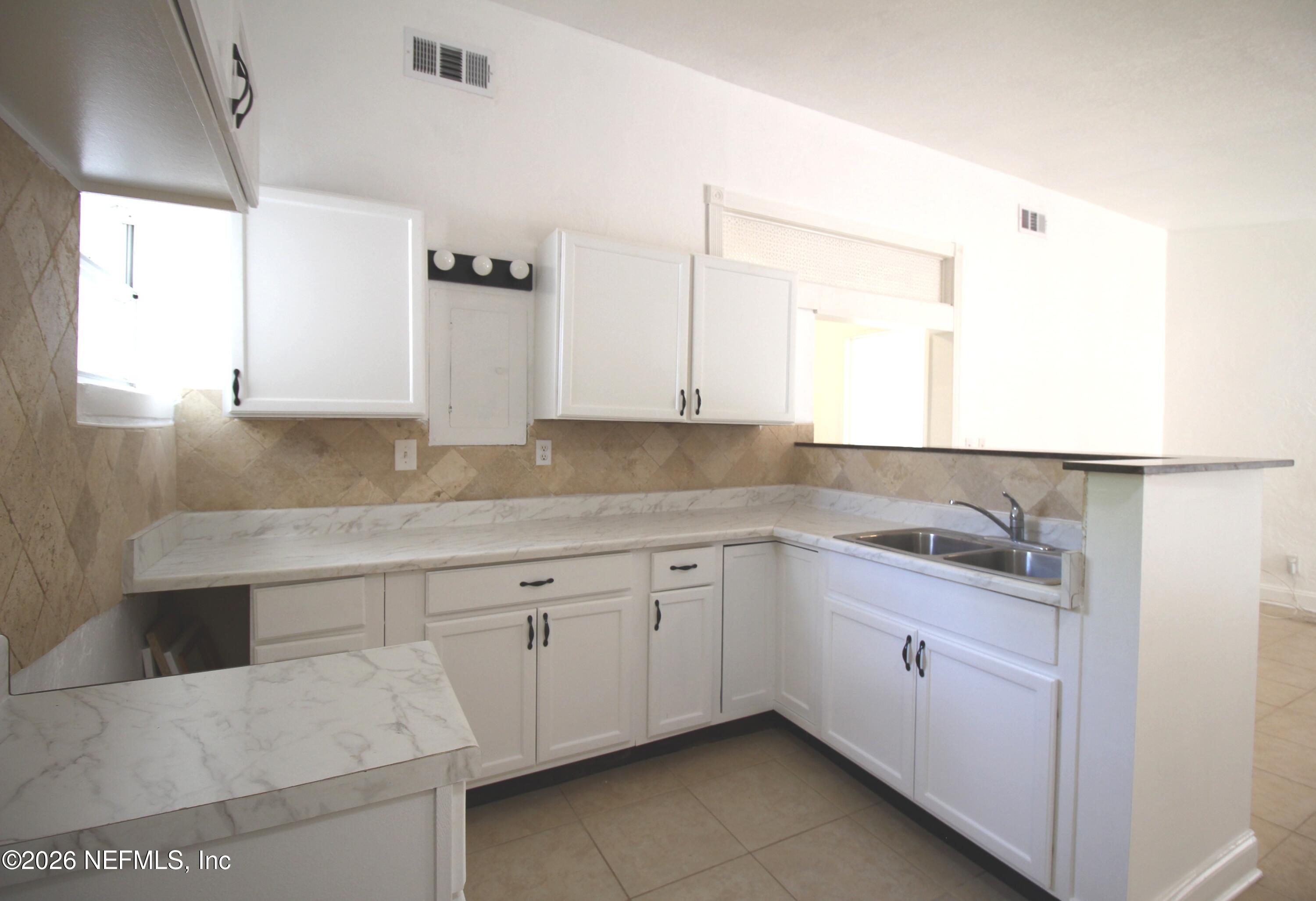 1304 King Arthur Road Jacksonville, FL 32211 - Photo 11 of 25 a kitchen with granite countertop white cabinets and sink
