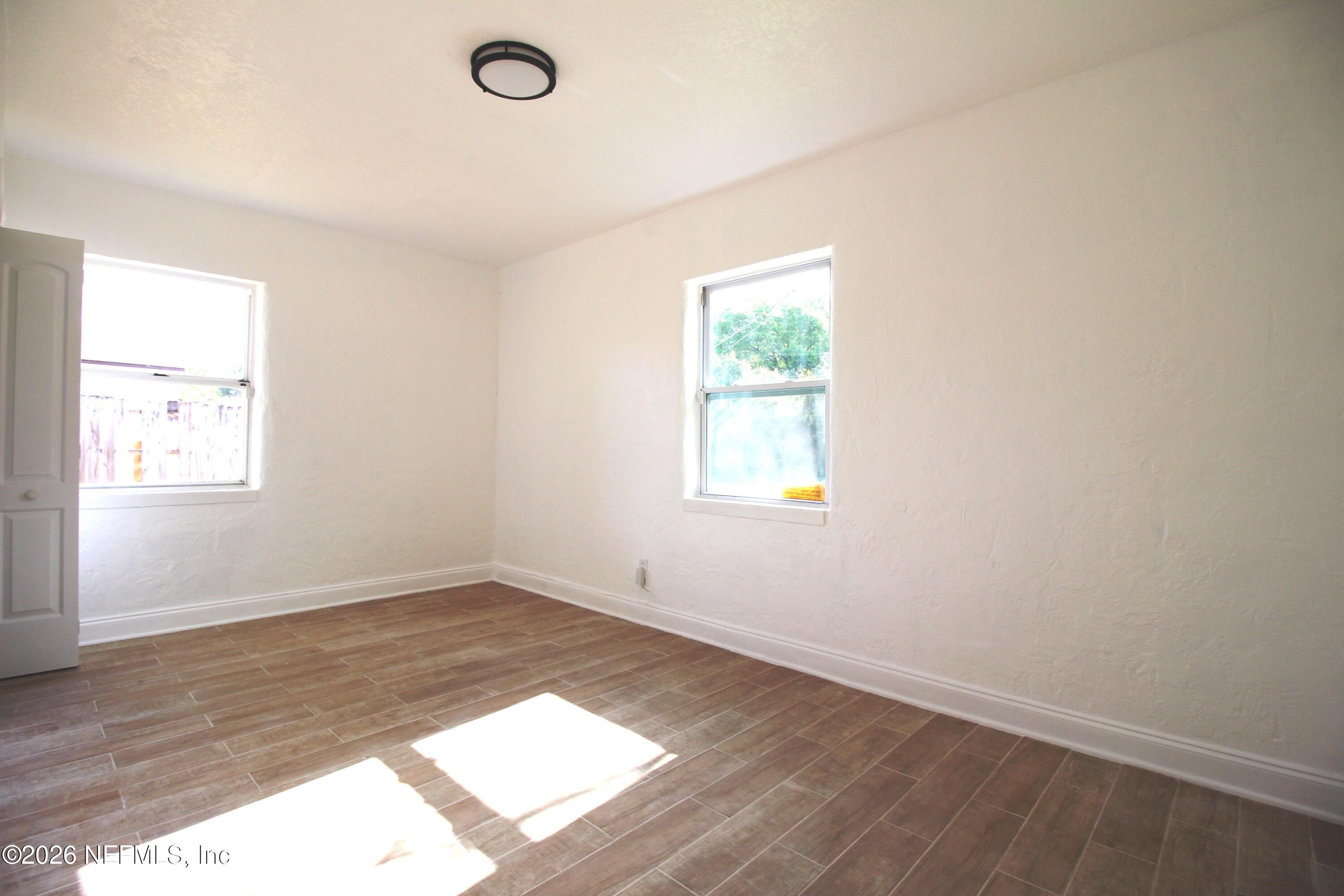 1304 King Arthur Road Jacksonville, FL 32211 - Photo 17 of 25 an empty room with wooden floor and windows