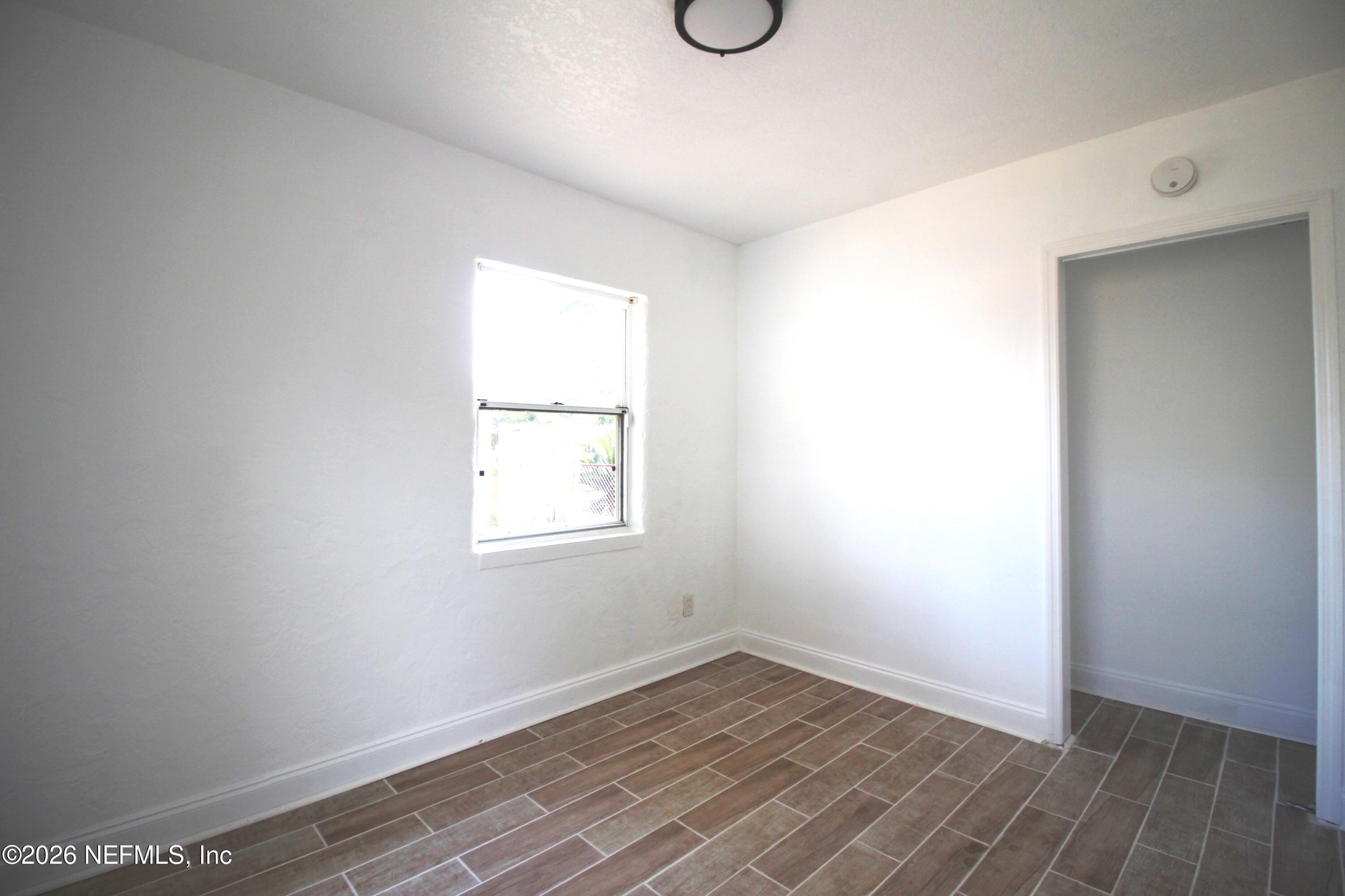 1304 King Arthur Road Jacksonville, FL 32211 - Photo 20 of 25 an empty room with wooden floor and windows