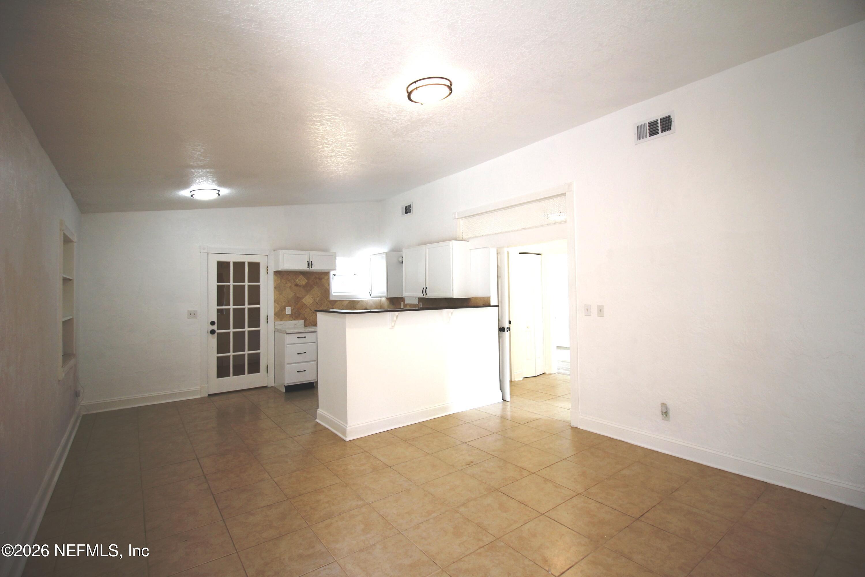 1304 King Arthur Road Jacksonville, FL 32211 - Photo 8 of 25 a view of kitchen with refrigerator and white cabinets
