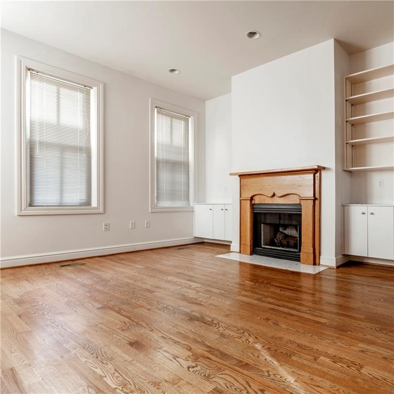326 Hailman Street Pittsburgh, PA 15206 - Photo 11 of 22 an empty room with wooden floor fireplace and windows