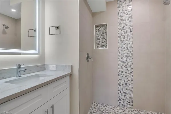a bathroom with a sink a vanity and a shower