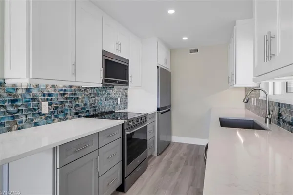 a kitchen with a sink stove and refrigerator
