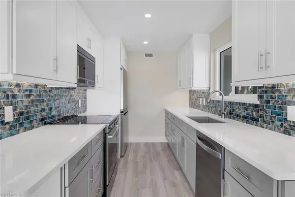 a kitchen with a sink stove and cabinets