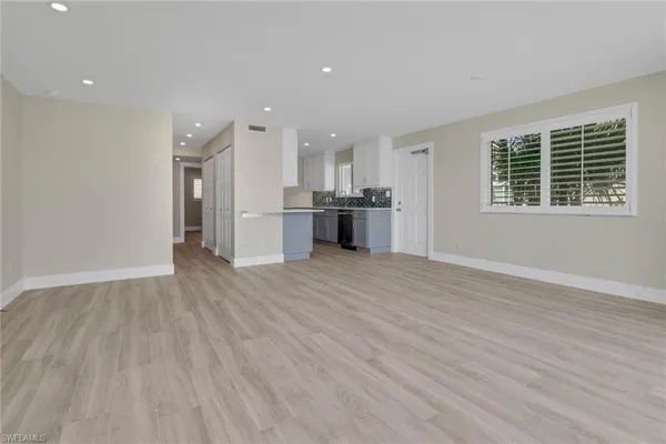 a large kitchen with stainless steel appliances granite countertop a large counter top and a wooden floor