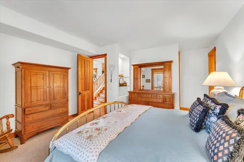 a bedroom with a bed and large windows