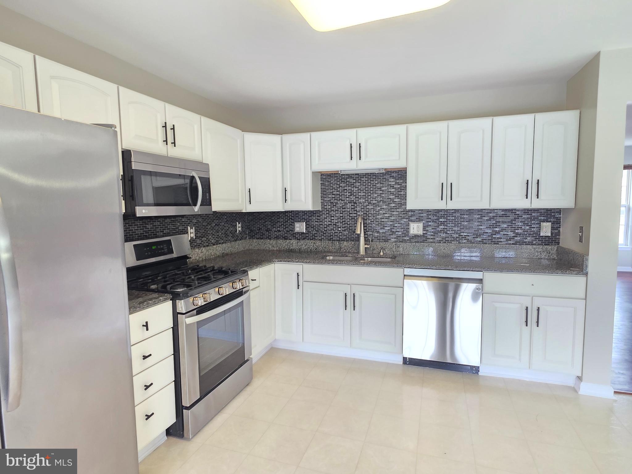 1002 Carlisle Road Egg Harbor Township, NJ 08234 - Photo 24 of 32 a kitchen with granite countertop white cabinets and stainless steel appliances