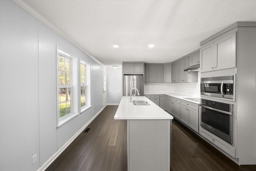 109 Summers Circle Azle, TX 76020 - Photo 11 of 32 a kitchen with stainless steel appliances kitchen island granite countertop a refrigerator and a stove top oven