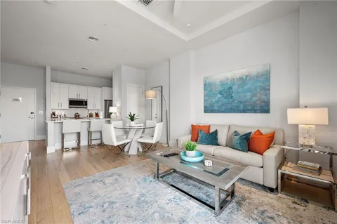 a living room with furniture and view of kitchen