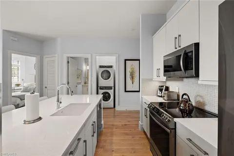 a kitchen that has a sink and a stove top oven