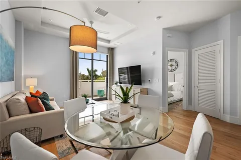 a living room with furniture a dining table and a chandelier