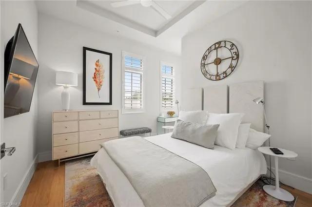 a bedroom with a large bed and a flat tv screen on dresser
