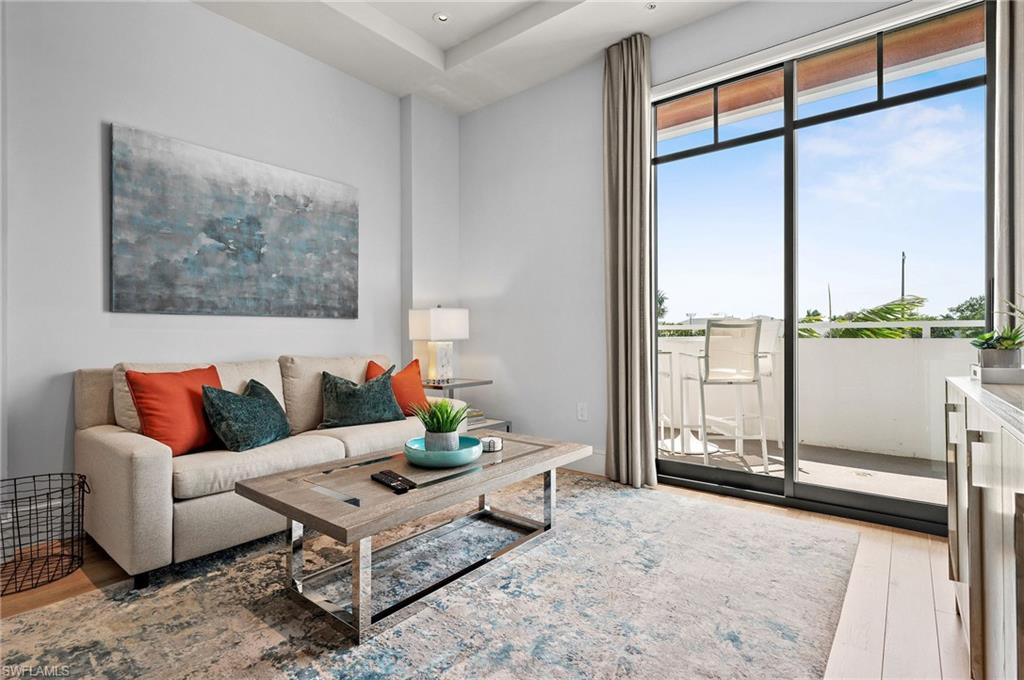 101 8th Street South, Unit 206 Naples, FL 34102 - Photo 2 of 26 a living room with furniture and a floor to ceiling window