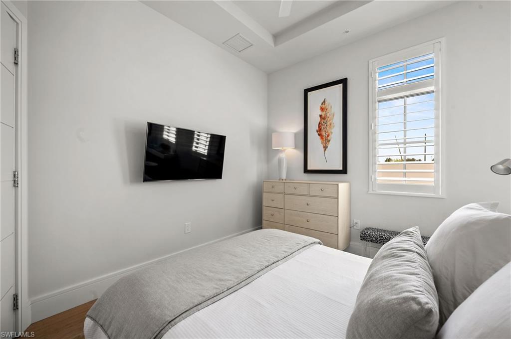 101 8th Street South, Unit 206 Naples, FL 34102 - Photo 21 of 26 a bedroom with a bed and a flat screen tv