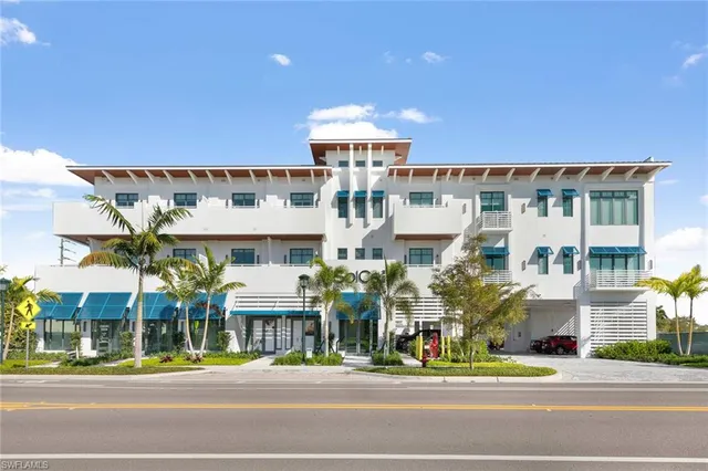 a front view of multi story residential apartment building with a yard