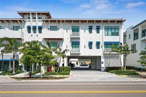 a front view of a building with a garden and plants