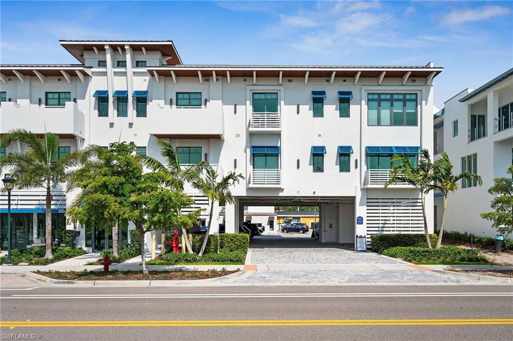101 8th Street South, Unit 206 Naples, FL 34102 - Photo 6 of 26 a front view of a building with a garden and plants