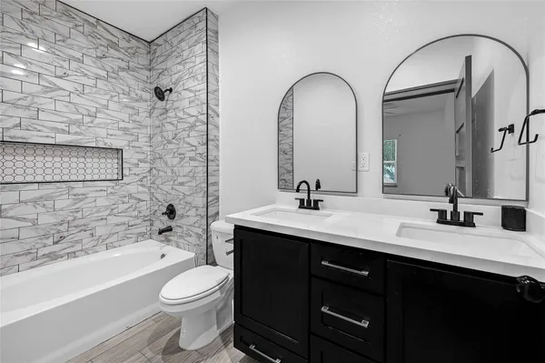 a bathroom with a double vanity sink toilet and shower