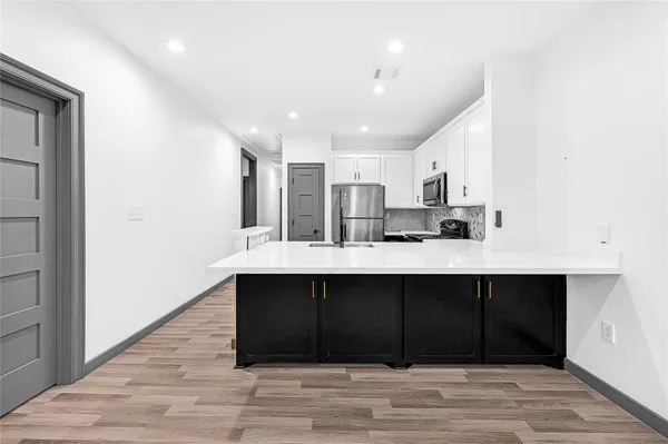 a kitchen with stainless steel appliances a sink and cabinets