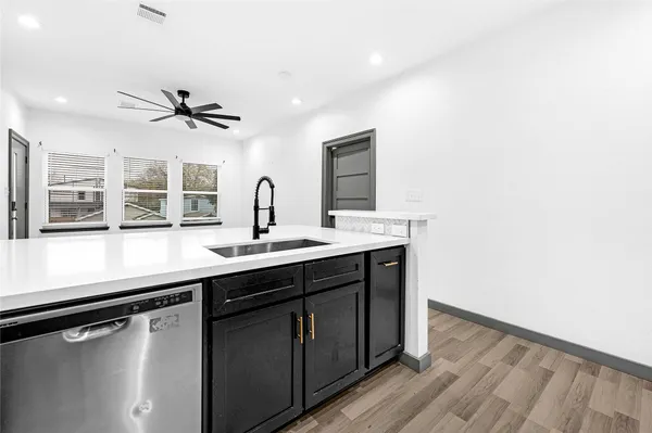 a kitchen with a sink stainless steel appliances and window