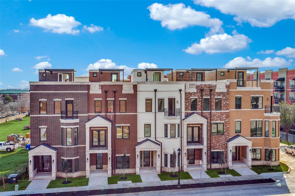 a front view of a residential apartment building with a yard in front of it