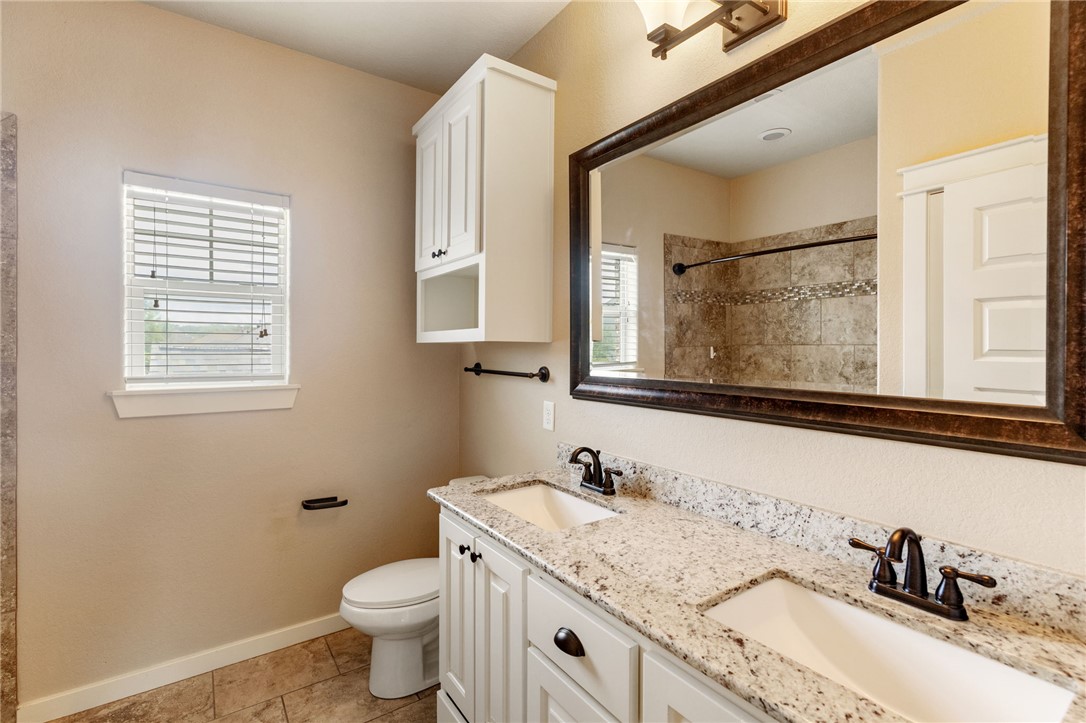 2136 Rockcliffe Loop College Station, TX 77845 - Photo 43 of 48 a bathroom with a granite countertop toilet sink and mirror
