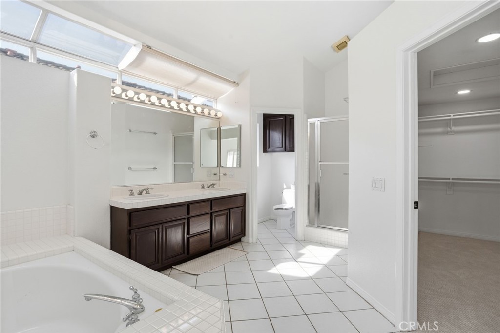 9916 Fonte Road Cypress, CA 90630 - Photo 14 of 27 a spacious bathroom with a bathtub sink and mirror