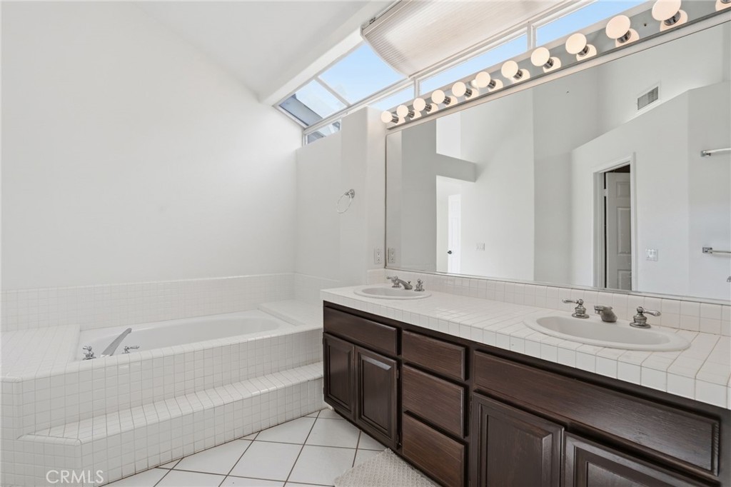 9916 Fonte Road Cypress, CA 90630 - Photo 15 of 27 a bathroom with a granite countertop sink mirror and a bathtub