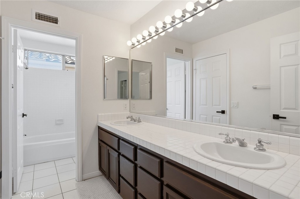 9916 Fonte Road Cypress, CA 90630 - Photo 19 of 27 a bathroom with a double vanity sink and a mirror