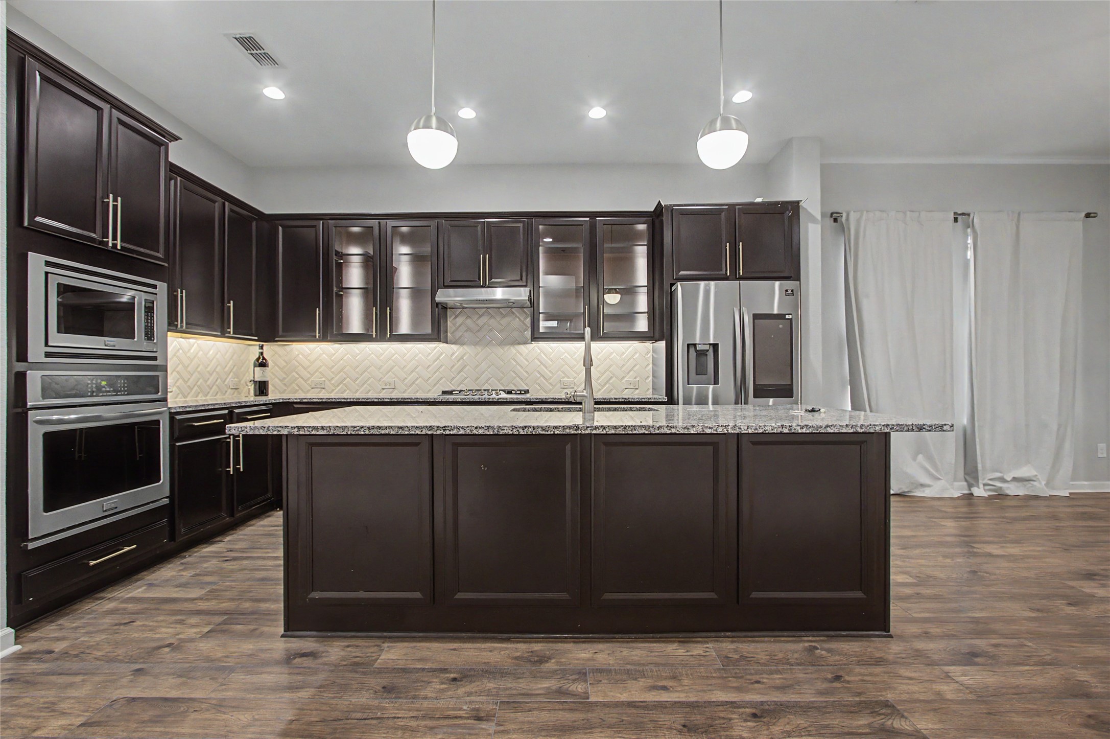 19718 Shinnery Ridge Court Cypress, TX 77433 - Photo 3 of 23 a kitchen with stainless steel appliances granite countertop a stove a sink and a microwave