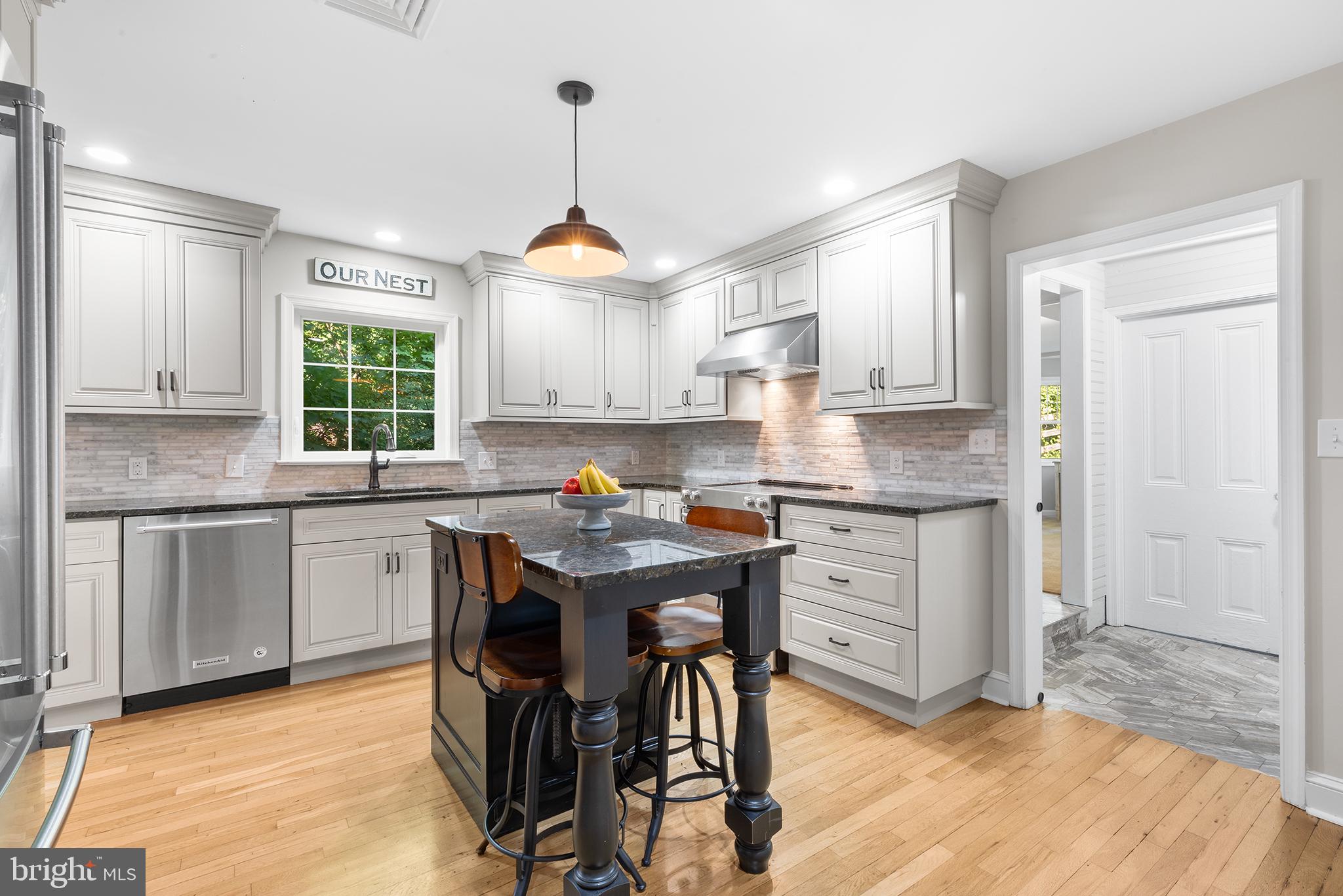 420 Berwyn Baptist Road Devon, PA 19333 - Photo 10 of 33 a kitchen with kitchen island granite countertop wooden floors and white cabinets