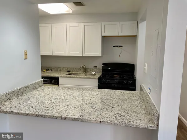 a kitchen with a stove and white cabinets
