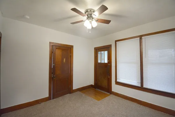 an empty room with closet and a ceiling fan