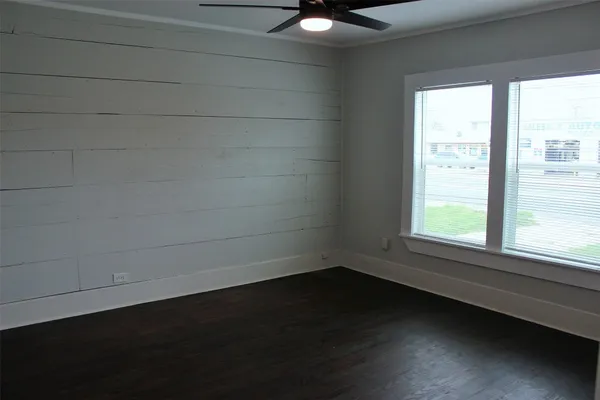 a view of a small space with wooden floor and a window